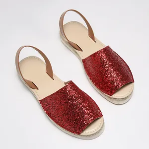 Detailed view of sparkling red glitter flat peep-toe sandals with tan straps and rope sole