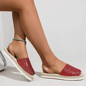 Detail shot of women's red glittery flat sandals with espadrille soles and peep-toe
