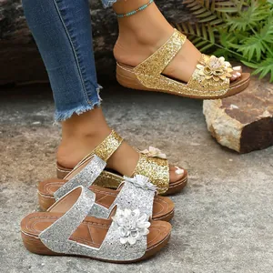Detailed view of glittery wedge sandals with floral accents in gold and silver options.