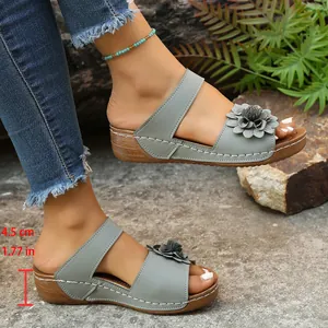 Macro view of grey wedge sandals featuring flower detail and 4.5 cm heel height.
