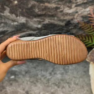 Detailed macro view of the textured non-slip rubber sole of a women's wedge sandal