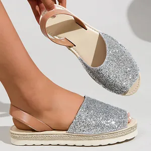 Close-up of silver glitter open-toe sandals with platform espadrille sole.