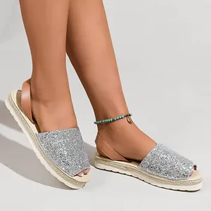 Stylish silver sequin peep-toe flat sandals for women, detailed view on model's feet.