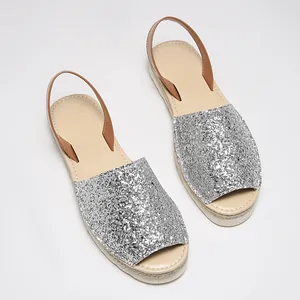 Detailed top view of silver glitter peep-toe sandals with woven espadrille soles