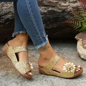 Side view of women's gold glitter wedge sandals featuring detailed 3D floral embellishment