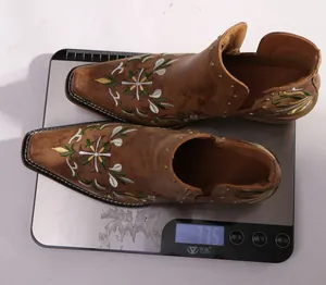 Detailed view of brown embroidered western ankle boots weighing 775 grams on a digital scale