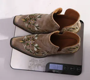 Detail view showing vintage embroidered Western boots with rivets weighing 776g on a scale