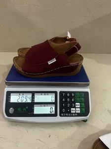 Weight measurement of red wedge sandals showing 209.4g for lightweight performance