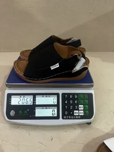 Lightweight black wedge sandals weighing 206.6 grams shown on a digital scale
