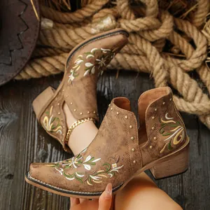 Vintage brown western ankle boots featuring intricate floral embroidery and gold stud accents