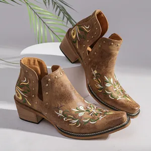 Detailed view of vintage embroidered Western ankle boots with metal studs and block heel