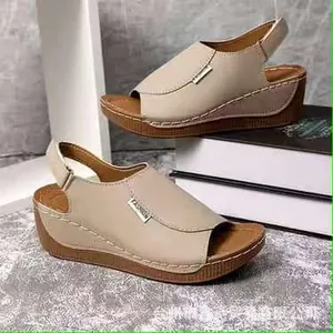 Detailed macro view of beige platform wedge sandals with elegant metal fashion label