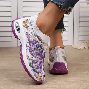 Détail de baskets en maille pour femmes avec imprimés papillons colorés et strass.