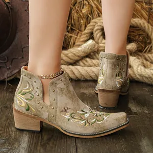 Detail view of vintage embroidered Western ankle boots with brass studs and block heel