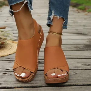 Close-up detail of stylish tan wedge platform sandals on a rustic wooden boardwalk