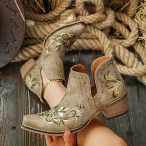 Detailed view of floral embroidery and metal studs on vintage Western ankle boots