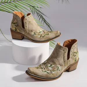 Detailed macro view of vintage western ankle boots with floral embroidery and gold studs