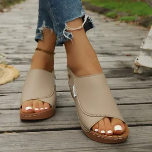 Detailed view of women's beige platform wedge sandals on a rustic wooden path