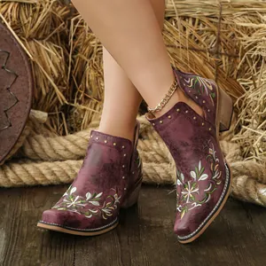 Close-up of vintage Western ankle boots with floral embroidery and rivet details