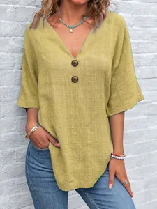 Dettaglio del top casual giallo senape con scollo a V, trama lino e bottoni