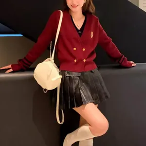 Detail eines roten doppelreihigen Cardigans im Preppy-Stil mit goldenen Knöpfen