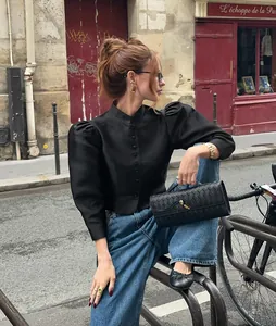 Elegant vintage black puff sleeve shirt with stand collar in a chic street style scene