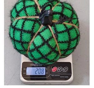 Detailed view of hand-knitted green Halloween pumpkin decoration weighing 208 grams