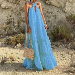 Light blue halter neck tiered maxi dress with 3D floral texture in a sunlit outdoor setting