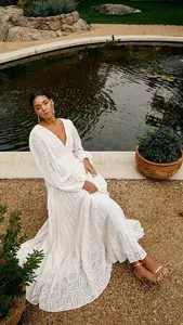 Elegant off-white long-sleeved pleated maxi dress with lantern sleeves in garden setting