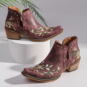 Detailed view of vintage embroidered western boots with metallic studs and ethnic patterns