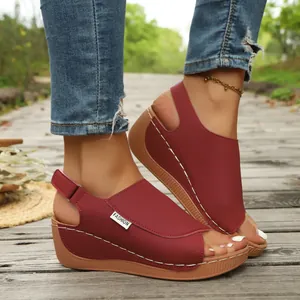 Close-up view of stylish maroon peep-toe wedge sandals with white contrast stitching