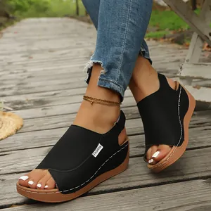 Detailed shot of black platform wedge sandals for women on a rustic wooden path