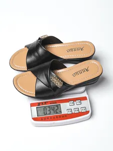 Detailed view of black wedge slide sandals for women weighing approximately 0.342kg on a scale