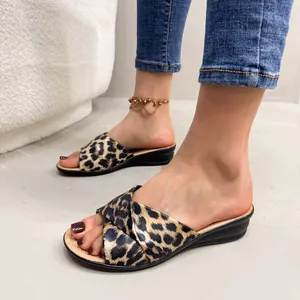 Detail shot of stylish leopard print wedge sandals for women with an open-toe design.