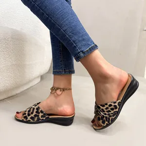 Detailed shot of stylish leopard print wedge slide sandals worn in a modern home setting