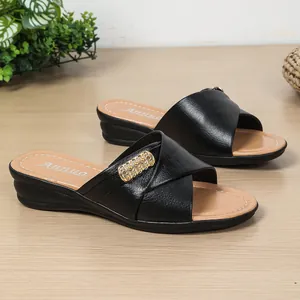 Elegant black leather wedge sandals for women featuring criss-cross straps and gold buckle detail