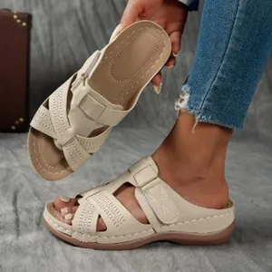Détail de sandales à plateforme compensées beige avec des motifs ajourés découpés au laser