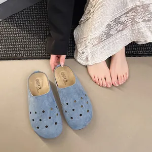 Dettaglio di sabot in pelle scamosciata blu con design traforato e suola spessa