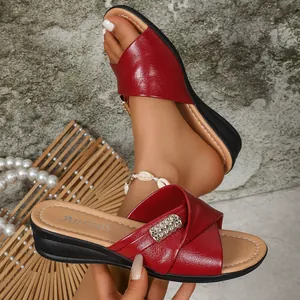Detailed view of red summer wedge sandals featuring a stylish metal rhinestone buckle