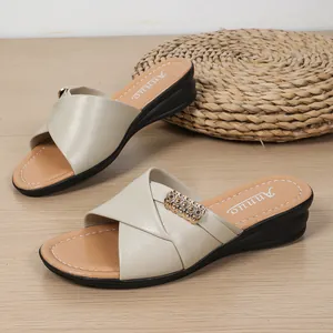 Detailed view of elegant beige wedge sandals with cross straps and gold metal accent