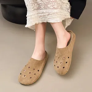 Vista dettagliata di eleganti sabot da donna in camoscio color cammello con fori decorativi