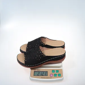 Close-up of lightweight black platform wedge sandals weighing 212.1g on a scale