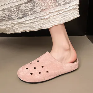 Primo piano di eleganti sabot in camoscio rosa traforato con suola spessa indossati
