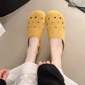 Zoccoli traforati in similpelle gialla indossati, sabot estivi casual da donna.