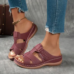 Sandales compensées bordeaux ajourées pour femmes portées avec un jean en denim bleu
