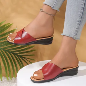 Elegant women's red wedge sandals featuring cross strap and stylish open toe design