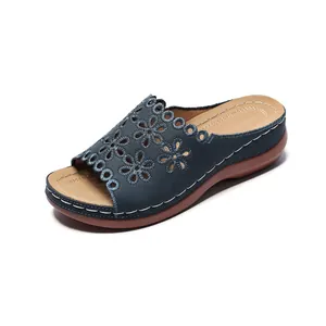 Elegant navy blue floral laser-cut wedge sandal with tan insole and white stitching detail