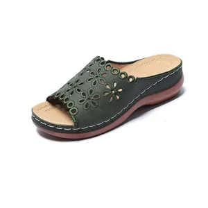 Detail view of green laser-cut floral pattern wedge sandal with thick sole and peep-toe