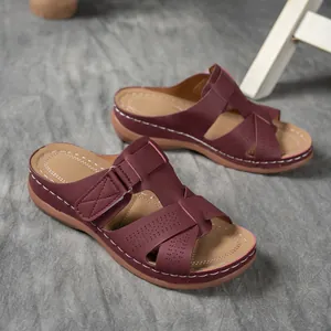 Vue latérale de sandales à talons compensés bordeaux avec motifs ajourés et coutures