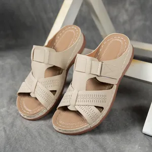 Vue détaillée de sandales à talons compensés beige avec motif ajouré et surpiqûres.